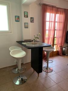 a kitchen with a black island with two stools at La Bandolaise à Perdika in Perdika