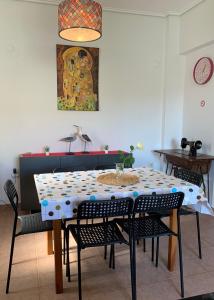 a dining room table with chairs and a painting on the wall at La Bandolaise à Perdika in Perdika