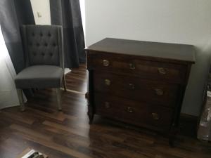 a wooden dresser and a chair in a room at Elbsandstein Apartments Altstadt in Erfurt