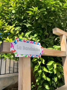 a sign on a wooden bench in front of a bush at La Bandolaise à Perdika in Perdika