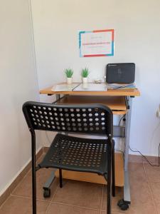 a black chair in front of a desk with a laptop at La Bandolaise à Perdika in Perdika