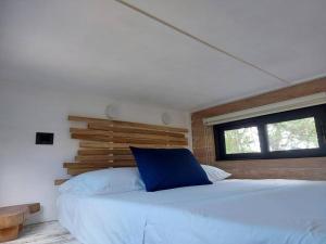 a bedroom with a bed with a blue pillow on it at Polita Tiny House, con piscina, a 200m de la playa in Holbox Island