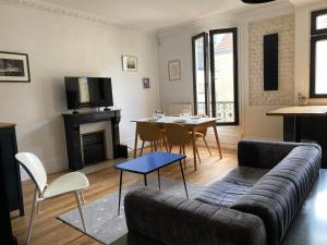 ein Wohnzimmer mit einem Sofa und einem Tisch in der Unterkunft Appartement à 50m de Paris in Clichy