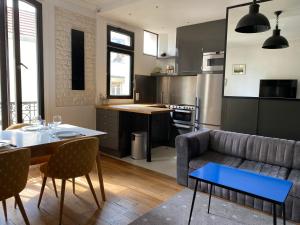 eine Küche und ein Wohnzimmer mit einem Sofa und einem Tisch in der Unterkunft Appartement à 50m de Paris in Clichy