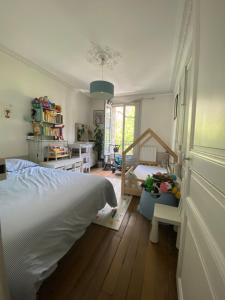 ein Schlafzimmer mit einem Bett und ein Zimmer mit einem Fenster in der Unterkunft Appartement à 50m de Paris in Clichy