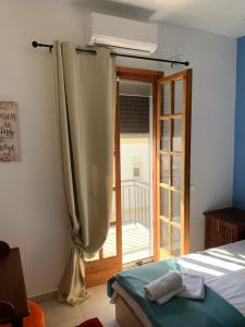 a bedroom with a bed and a sliding glass door at La Bandolaise à Perdika in Perdika