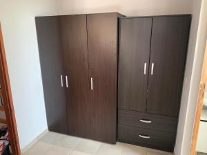 a large closet with brown cabinets in a room at La Bandolaise à Perdika in Perdika