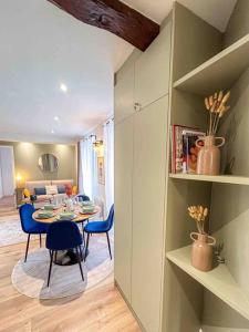 a dining room and living room with a table and chairs at La vie est belle à Paris Metro 9 in Montreuil