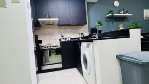 a kitchen with a washing machine and a sink at Elite Master Room in Dubai Marina Near Blue Water in Dubai