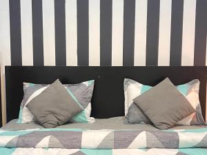 a bed with a black and white headboard and pillows at Elite Master Room in Dubai Marina Near Blue Water in Dubai