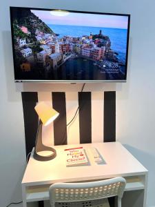 a tv on a wall with a desk with a lamp at Elite Master Room in Dubai Marina Near Blue Water in Dubai