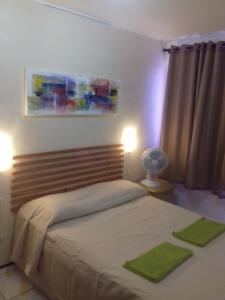 um quarto com 2 camas com toalhas verdes em Apartamento Praia de Iracema em Fortaleza