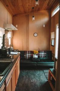 un soggiorno con divano e orologio sul muro di Adirondack Country Living Tiny House Village a Canton