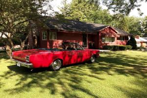 ein rotes Auto, das vor einem Haus parkt in der Unterkunft The Red House in Richmond