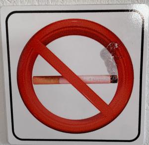 a sign with a no smoking sign with a cigarette at La Bandolaise à Perdika in Perdika