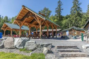 um pavilhão de madeira com uma mesa de piquenique e algumas rochas em R & R Chalet at Mt. Rainier em Ashford