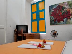 Zimmer mit einem Tisch mit 2 Handtüchern und einem TV in der Unterkunft Casa de huéspedes la Casona. in Medellín
