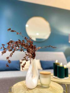 a table with two white vases on a table with candles at L‘Éden au Porte de Paris Metro 9 in Montreuil