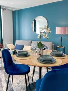 a dining room with a table and blue walls at L‘Éden au Porte de Paris Metro 9 in Montreuil