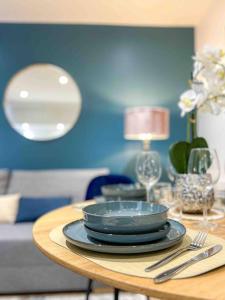 a table with plates and glasses and a blue wall at L‘Éden au Porte de Paris Metro 9 in Montreuil +8 photos