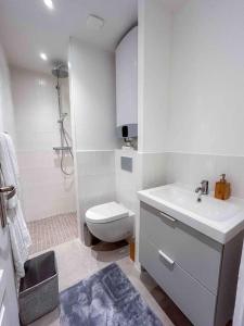 ein weißes Bad mit einem WC und einem Waschbecken in der Unterkunft L‘Éden au Porte de Paris Metro 9 in Montreuil