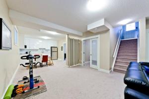 una sala de estar con sofá y una habitación con escaleras en Home Away From Home en Calgary