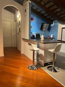 eine Küche mit einer Theke und Hockern in einem Zimmer in der Unterkunft StaraGo Apartment in Gorizia
