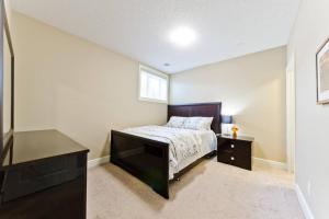 1 dormitorio con 1 cama, vestidor y ventana en Home Away From Home, en Calgary