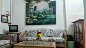 ein Wohnzimmer mit einem Sofa und einem Tisch in der Unterkunft Casa de huéspedes la Casona. in Medellín