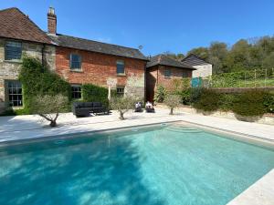 a large swimming pool in front of a house at The Dinton Dovecote in Salisbury
