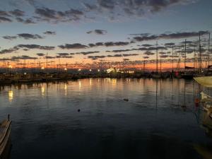 a marina with boats in the water at sunset at La Bandolaise à Perdika in Perdika
