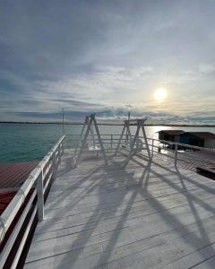een houten pier met zonsondergang boven het water bij Egang-egang Resort Bum-Bum Island Semporna in Semporna
