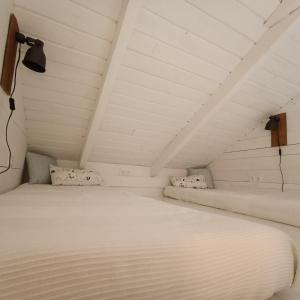 ein weißes Bett mit zwei Kissen in einem Zimmer in der Unterkunft Domek przy Majątku Morgi in Suchowola