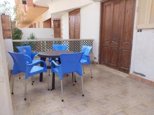 a table and blue chairs on a patio at Beachside Chalet ,Sidi kerir in Abû Zeira