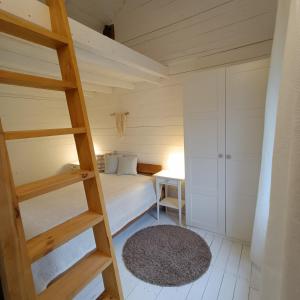 ein kleines Schlafzimmer mit einem Etagenbett und einer Leiter in der Unterkunft Domek przy Majątku Morgi in Suchowola + 17 Fotos