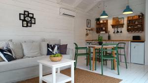 a living room with a couch and a table and chairs at Domek przy Majątku Morgi in Suchowola