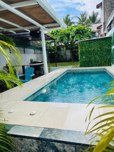 a swimming pool in a backyard with a pergola at CasaLu in Puntarenas