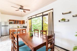 cocina y comedor con mesa de madera y sillas en Penthouse Suite w/ Ocean and Pool View, en Nicoya