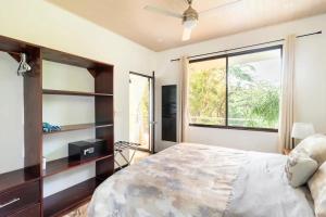 Un dormitorio con una cama grande y una ventana en Penthouse Suite w/ Ocean and Pool View, en Nicoya