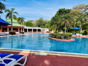 una gran piscina en un complejo con palmeras en 3BR/3.5BA Golf & Beach Villa, en Río Hato