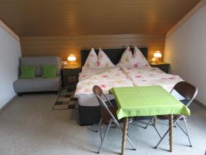 una camera da letto con un letto e un tavolo e sedie verdi di Haus Elena a Lainach