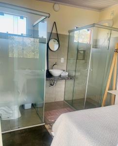 a bathroom with a glass shower and a sink at Chales Estrela Veadeiros in Alto Paraíso de Goiás