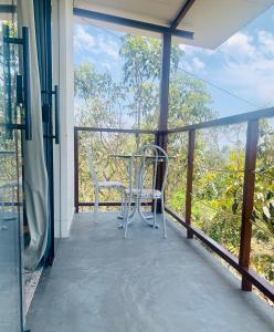 un balcón con mesa y 2 sillas. en Chales Estrela Veadeiros, en Alto Paraíso de Goiás