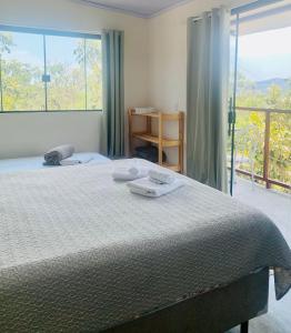 1 dormitorio con cama y ventana grande en Chales Estrela Veadeiros, en Alto Paraíso de Goiás