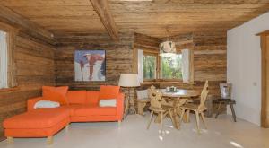 a living room with an orange couch and a table at Chalet Stockerdörfl Apartment 68m2 by ONE-VILLAS in Kitzbühel
