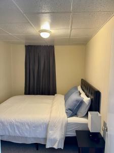 a bedroom with a bed with white sheets and a window at Island View House BnB Self Check-In in Portland