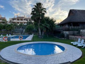 een zwembad in een tuin met stoelen en een huis bij Casa Rust en Ruimte in Murcia