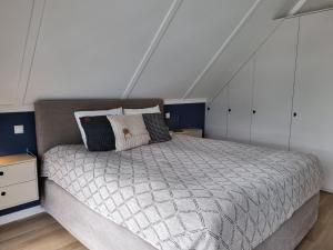 1 dormitorio con 1 cama grande y armarios blancos en Luxurious detached water villa with jetty, en Balk