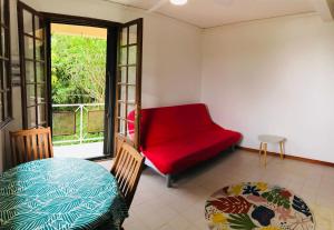 sala de estar con sofá rojo y ventana en Top Hill appartements et dortoir - Martinique, en La Trinité