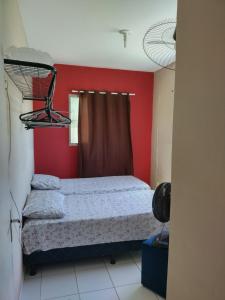 a bedroom with a bed and a red wall at Casa de praia para temporada in Paulista